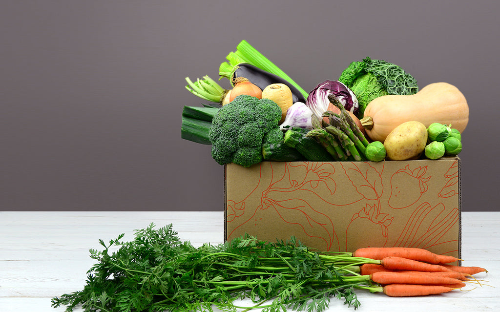 A mix of Seasonal Vegetables including salad, potatoes, carrots onion, garlic in a Vegetable Box